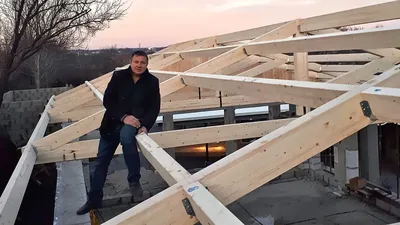 Alexandru, fondatorul LEMNER.MD, pe o structură de acoperiș din lemn lamelar