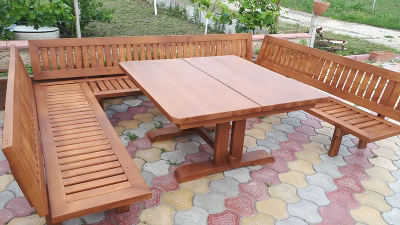 Set masă cu bănci de colț din lemn, pe pavaj, în grădină — LEMNER.MD