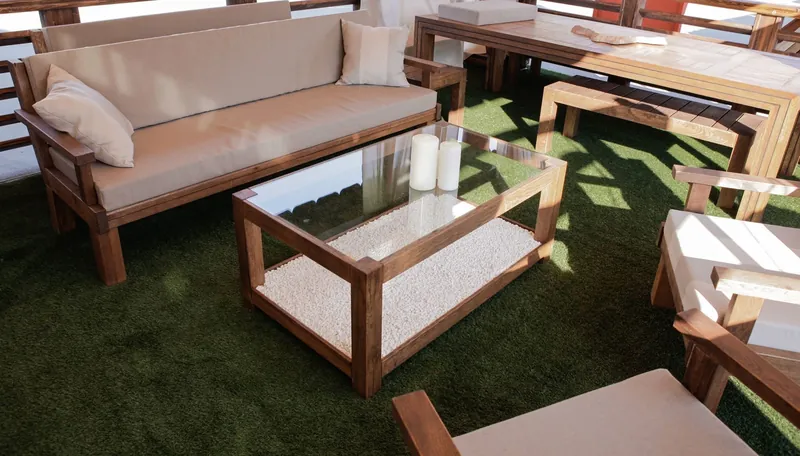 Set de lounge din lemn cu canapea, fotolii și masă joasă cu blat de sticlă, pe gazon — LEMNER.MD